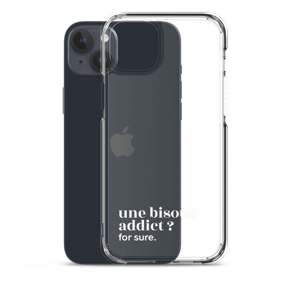 Coque iPhone 15 Plus, texte blanc, à côté du téléphone : « une bisous addict ? for sure. »