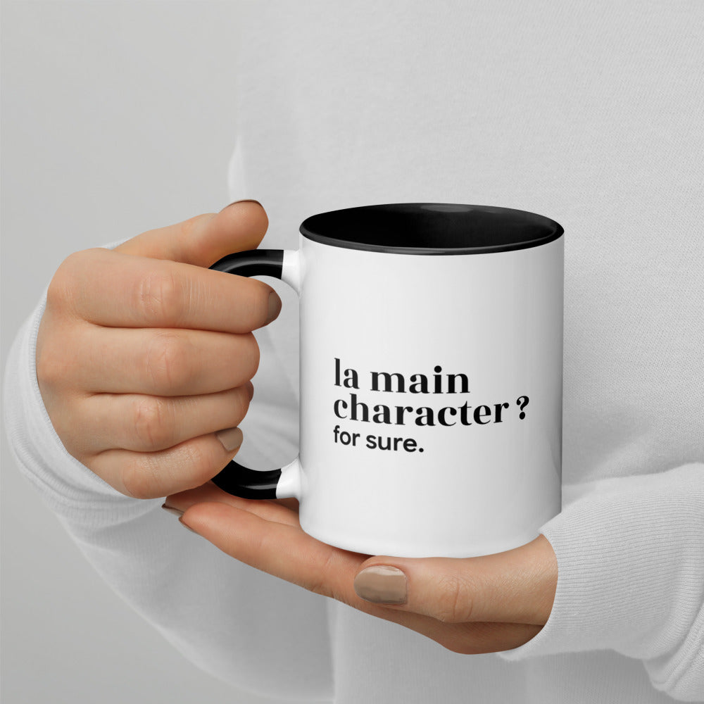 Mug intérieur noir « la main character ? for sure. », tenu dans les mains