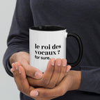 Mug intérieur noir « le roi des vocaux ? for sure. », tenu dans les mains