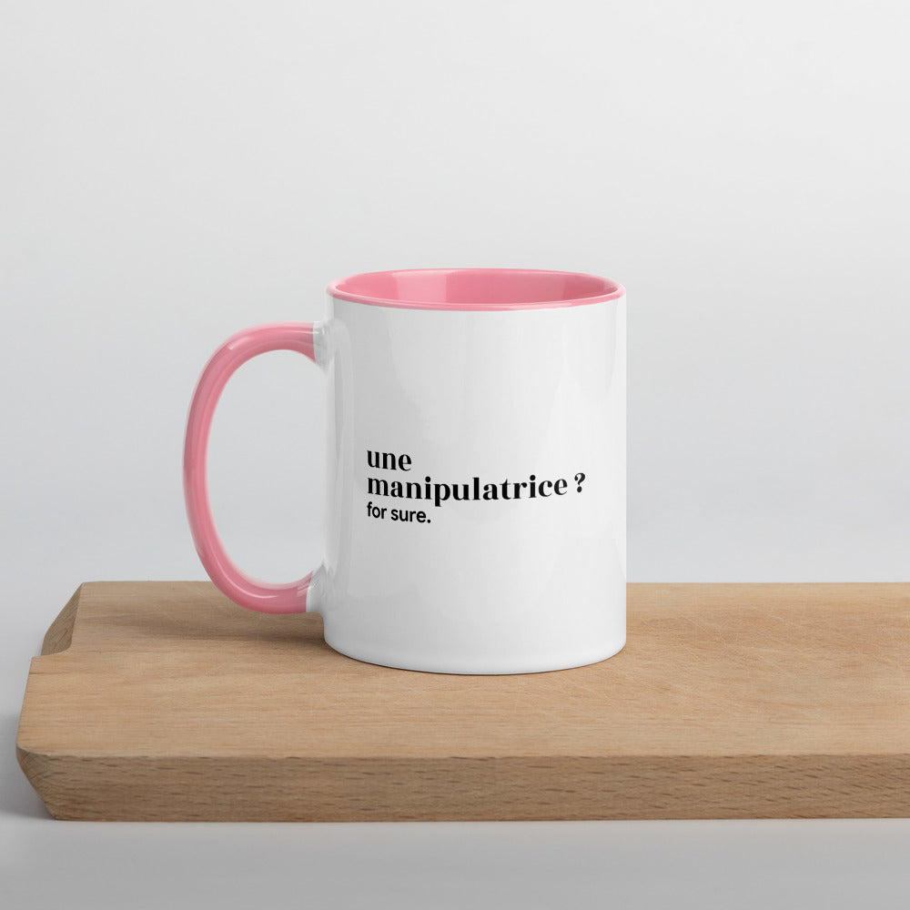 Mug intérieur rose « une manipulatrice ? for sure. », sur une planche en bois