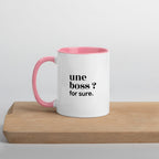 Mug intérieur rose « une boss ? for sure. », sur une planche en bois