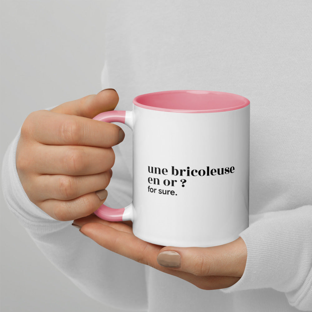 Mug intérieur rose « une bricoleuse en or ? for sure. », tenu dans les mains