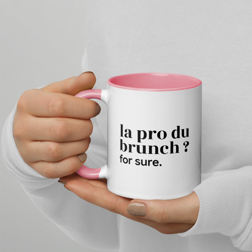 Mug intérieur rose « la pro du brunch ? for sure. », tenu dans les mains