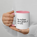 Mug intérieur rose « la reine des jeux ? for sure. », tenu dans les mains