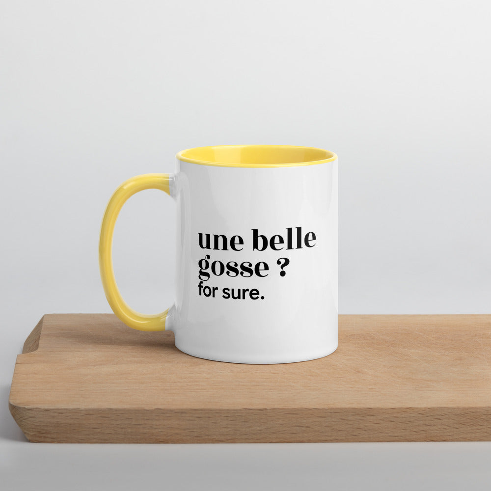 Mug intérieur jaune « une belle gosse ? for sure. », sur une planche en bois