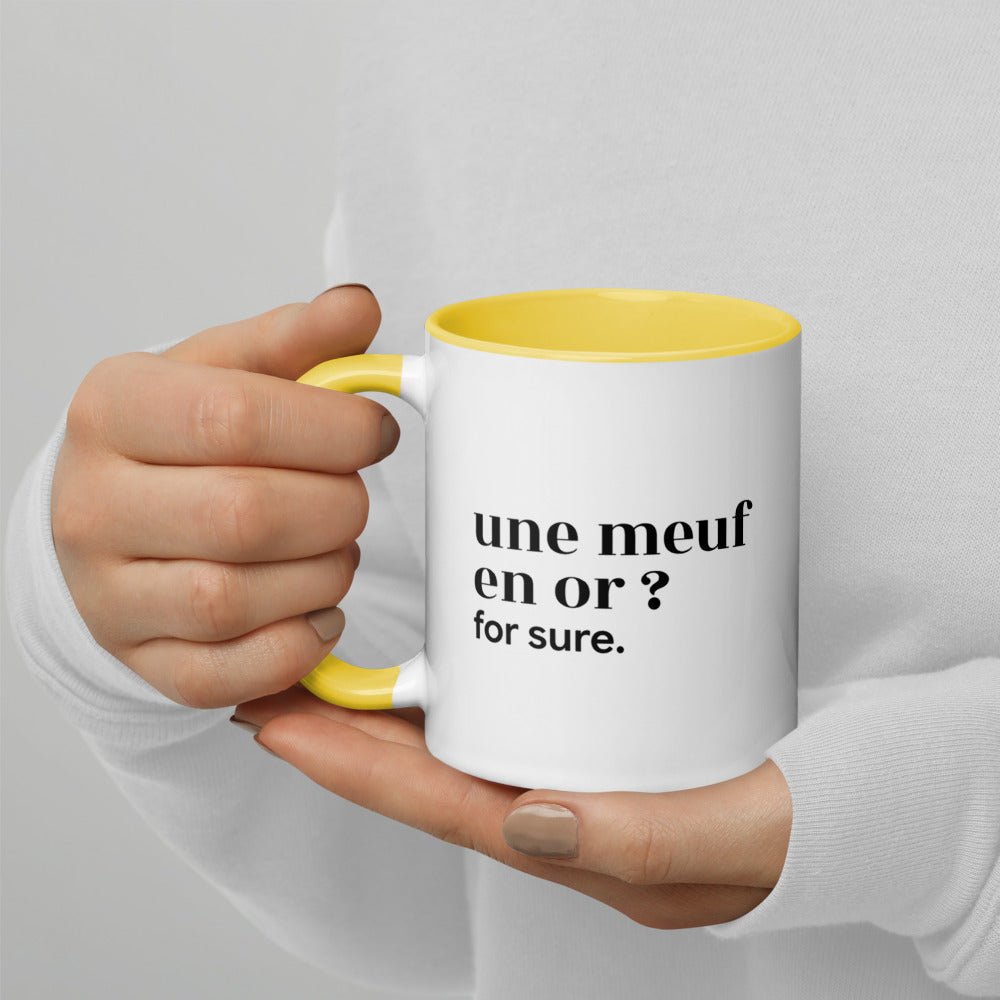 Mug intérieur jaune « une meuf en or ? for sure. », tenu dans les mains