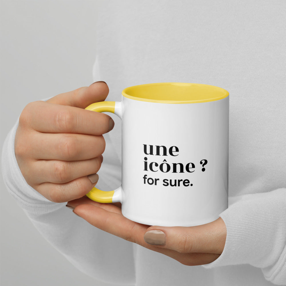 Mug intérieur jaune « une icône ? for sure. », tenu dans les mains