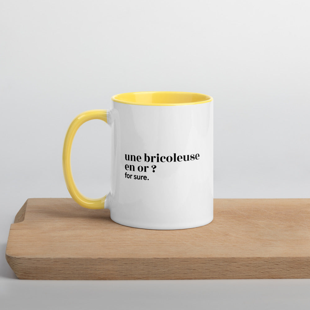 Mug intérieur jaune « une bricoleuse en or ? for sure. », sur une planche en bois