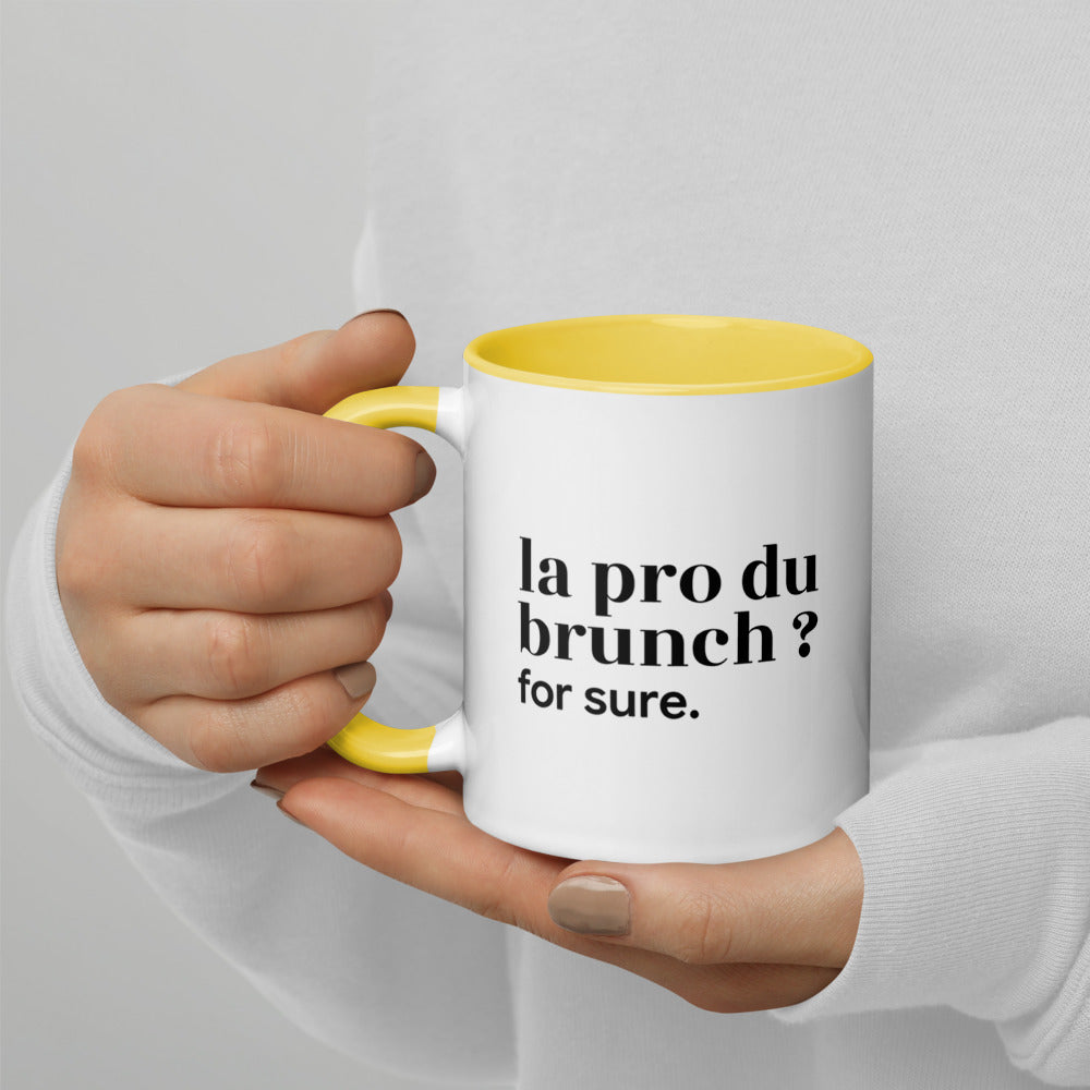 Mug intérieur jaune « la pro du brunch ? for sure. », tenu dans les mains