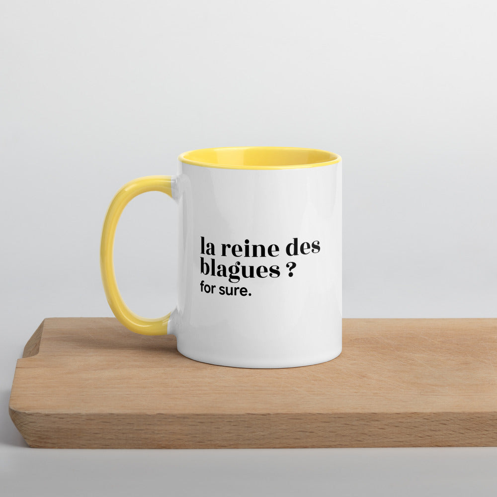 Mug intérieur jaune « la reine des blagues ? for sure. », sur une planche en bois