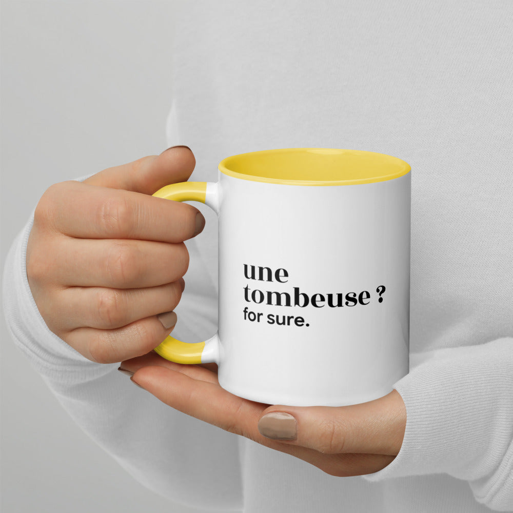 Mug intérieur jaune « une tombeuse ? for sure. », tenu dans les mains
