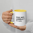 Mug intérieur jaune « une sex addict ? for sure. », tenu dans les mains