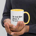 Mug intérieur jaune « le roi des jeux ? for sure. », tenu dans les mains
