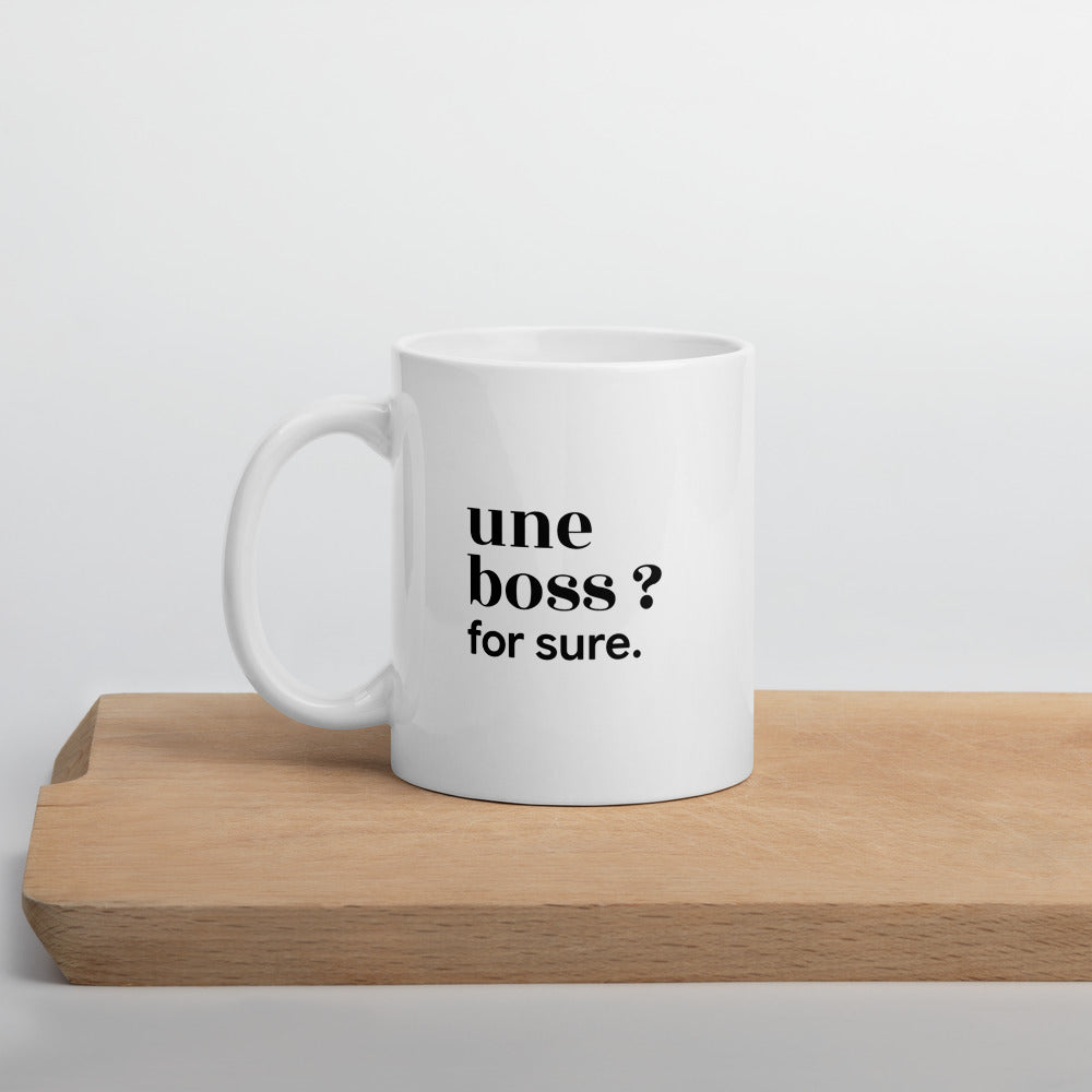 Mug blanc « une boss ? for sure. », sur une planche en bois