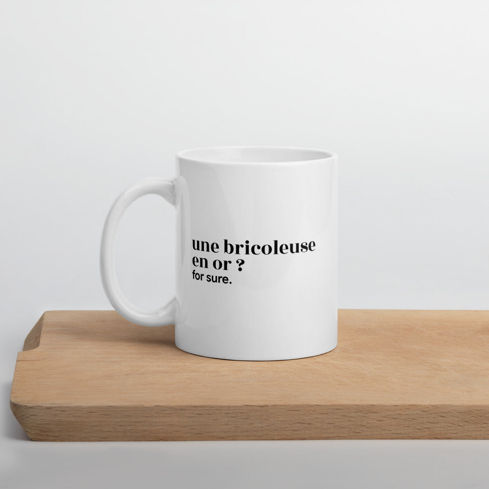 Mug blanc « une bricoleuse en or ? for sure. », sur une planche en bois
