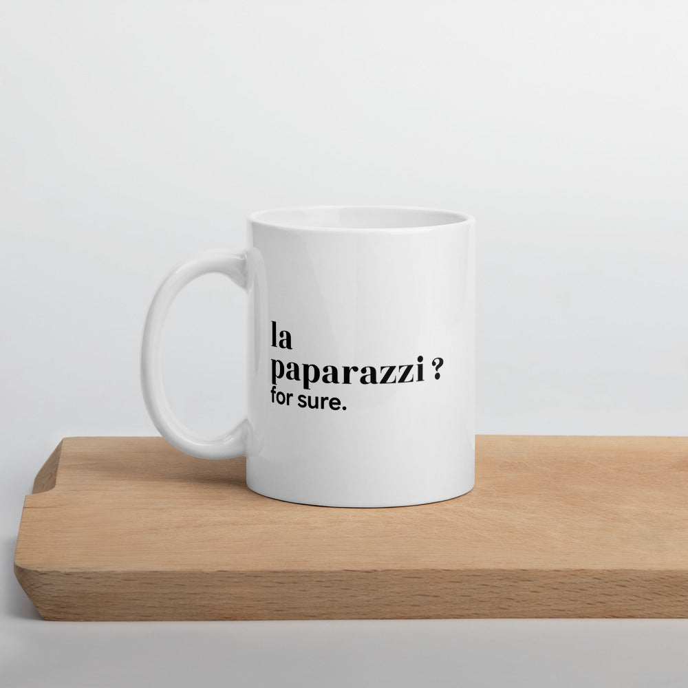 Mug blanc « la paparazzi ? for sure. », sur une planche en bois