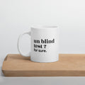 Mug blanc « un blind test ? for sure. », sur une planche en bois