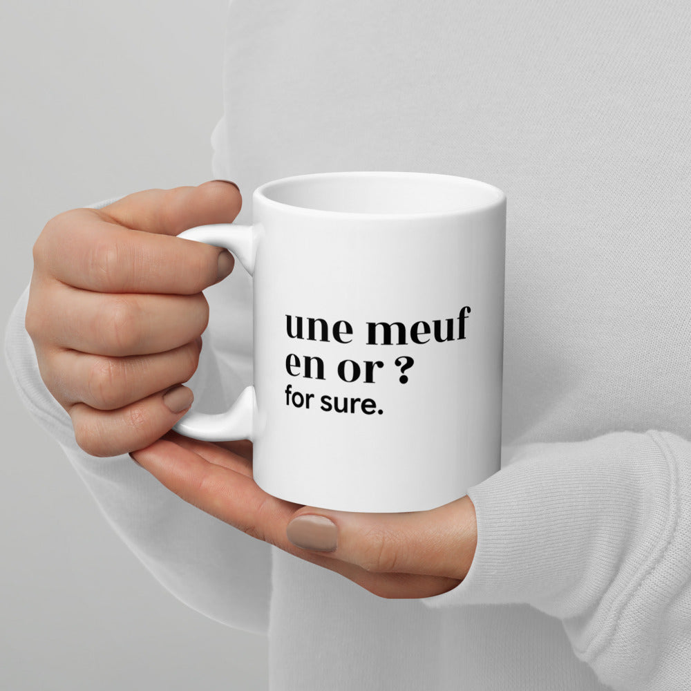 Mug blanc « une meuf en or ? for sure. », tenu dans les mains
