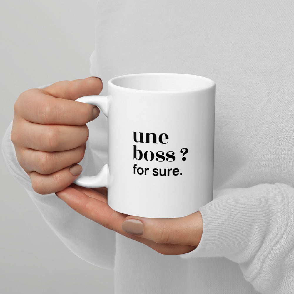 Mug blanc « une boss ? for sure. », tenu dans les mains