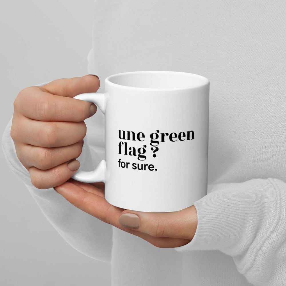 Mug blanc « une green flag ? for sure. », tenu dans les mains