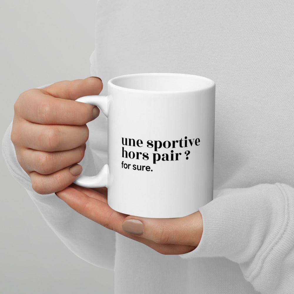 Mug blanc « une sportive hors pair ? for sure. », tenu dans les mains