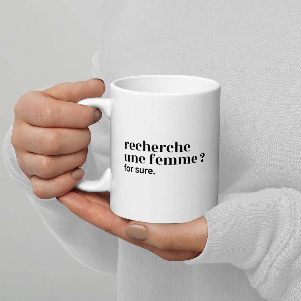 Mug blanc « recherche une femme ? for sure. », tenu dans les mains