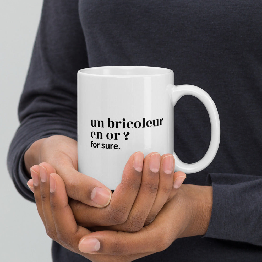 Mug blanc « un bricoleur en or ? for sure. », tenu dans les mains