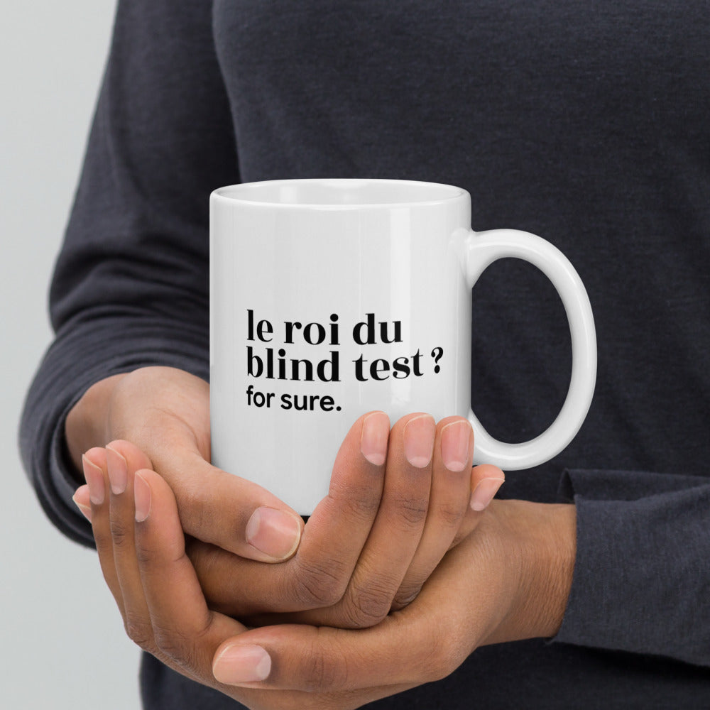 Mug blanc « le roi du blind test ? for sure. », tenu dans les mains
